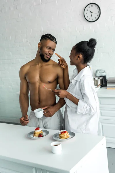 African american girlfriend pointing on boyfriend at kitchen — Stock Photo