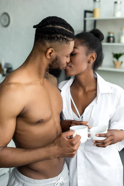 Africano casal americano beijando na cozinha — Fotografia de Stock