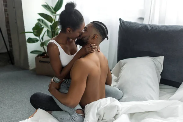 Afectuosa pareja afroamericana besándose en el dormitorio - foto de stock