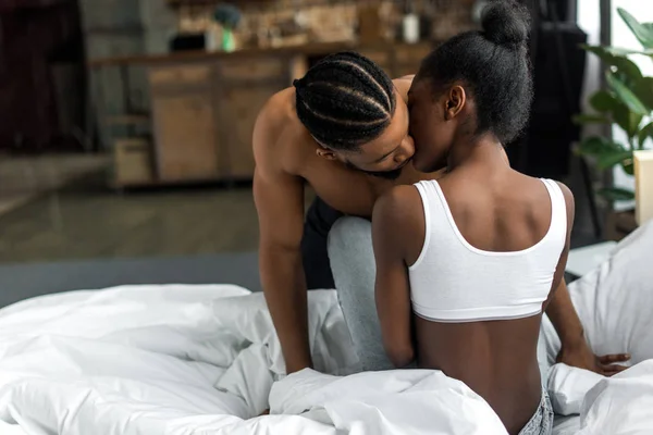 Pareja afroamericana apasionada besándose en el dormitorio - foto de stock