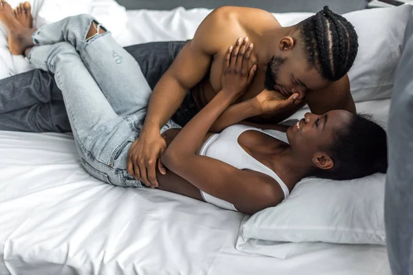 Africano casal americano deitado na cama no quarto — Fotografia de Stock