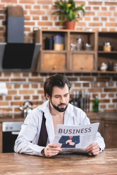 Gutaussehender Einzelgänger, der morgens in der Küche Zeitung liest — Stockfoto