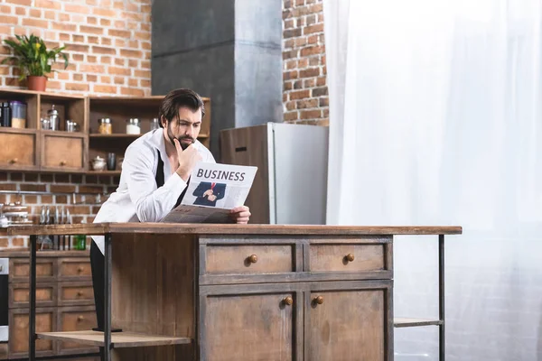 Bell'uomo d'affari solitario che legge il giornale in cucina — Foto stock