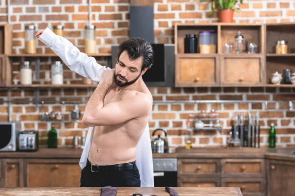 Bonito solitário empresário vestindo camisa de manhã na cozinha — Fotografia de Stock