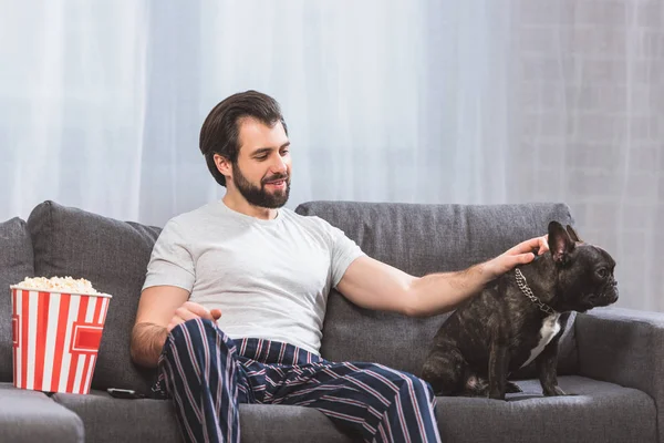 Schöne Einzelgängerin palmt Bulldogge auf Sofa zu Hause — Stockfoto
