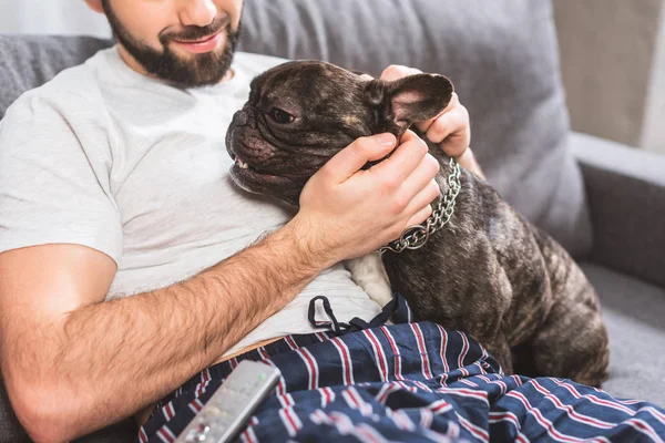 Cropped image of loner palming dog in living room — Stock Photo