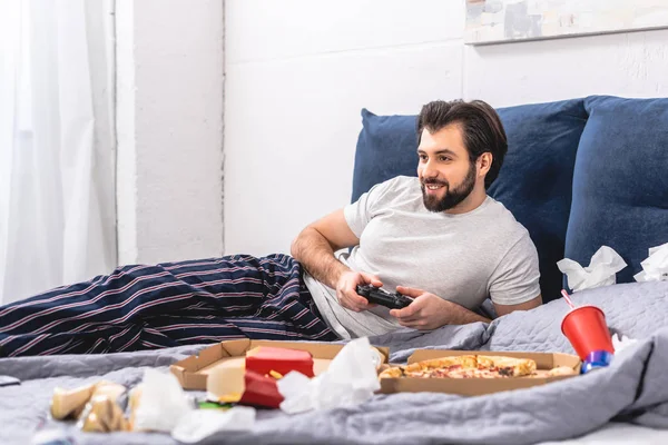 Щасливий чоловік-вчитель грає у відеоігри в спальні — стокове фото