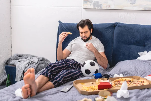 Bonito solitário comer pizza no cama no quarto — Fotografia de Stock