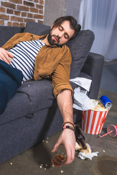 Loner sleeping on sofa with glass of whiskey at living room — Stock Photo