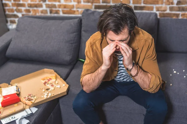 Schöner Einzelgänger mit Kopfschmerzen am Morgen und anrührender Nasenbrücke im Wohnzimmer — Stockfoto