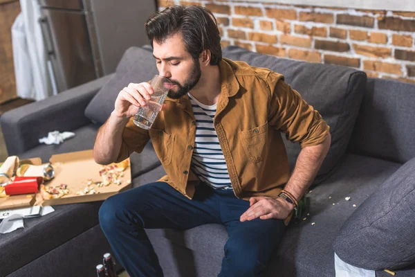 Beau solitaire eau potable et ayant la gueule de bois dans le salon — Photo de stock