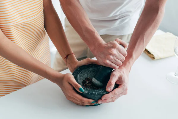 Cropped shot of couple using wooden pestle at table — Stock Photo