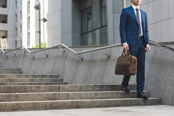 Plan recadré d'homme d'affaires en costume élégant avec mallette descendant les escaliers — Photo de stock