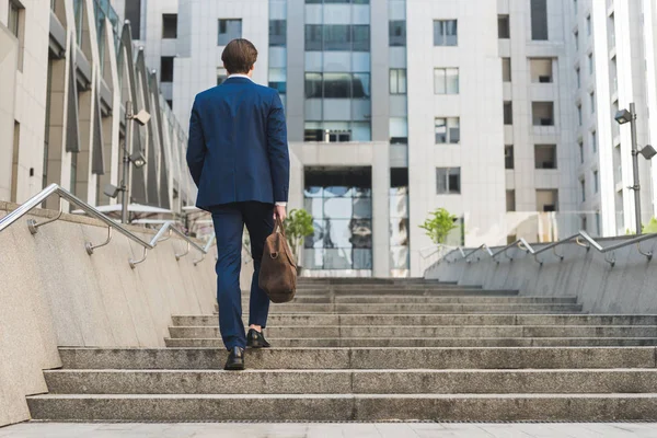 Rückansicht des Geschäftsmannes im schicken Anzug mit Lederaktentasche, die Treppe hinauf — Stockfoto