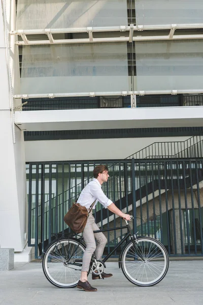 Side view of stylish young man riding vintage bicycle on city street — Stock Photo