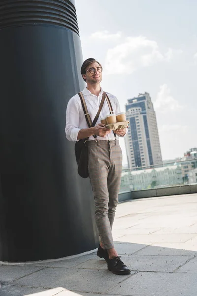 Schöner junger Mann mit Pappkaffeetassen auf Papptablett — Stockfoto