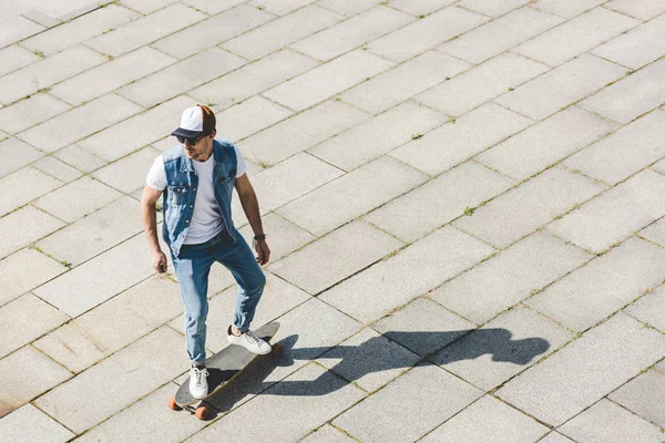 Vue grand angle de beau jeune patineur équitation skateboard par carré — Photo de stock