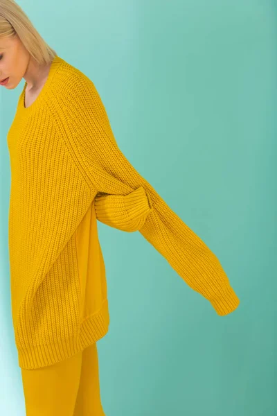 Corte tiro de mulher em suéter amarelo posando no fundo azul — Fotografia de Stock