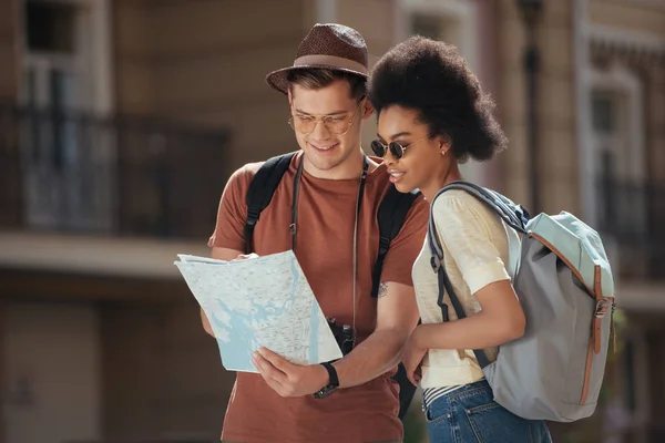 Casal de turistas em óculos de sol com mapa à procura de destino — Fotografia de Stock