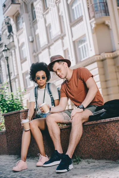 Tired couple of tourists sitting with disposable cups of coffee — Stock Photo