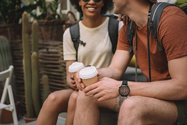 Abgeschnittenes Bild eines Paares, das mit Einwegbechern Kaffee sitzt — Stockfoto