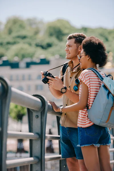Jovem turista masculino com câmera e afro-americana namorada — Fotografia de Stock