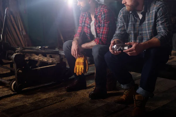 Plan recadré de deux travailleurs portant des gants de protection et des lunettes à la scierie — Photo de stock