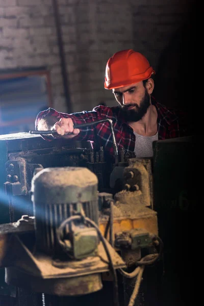 Operaio in casco protettivo riparazione macchina utensile presso segheria — Foto stock