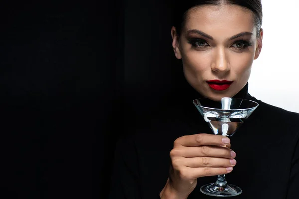 Красива елегантна жінка з червоними губами тримає мартіні склянки ізольовані на білому і чорному — стокове фото