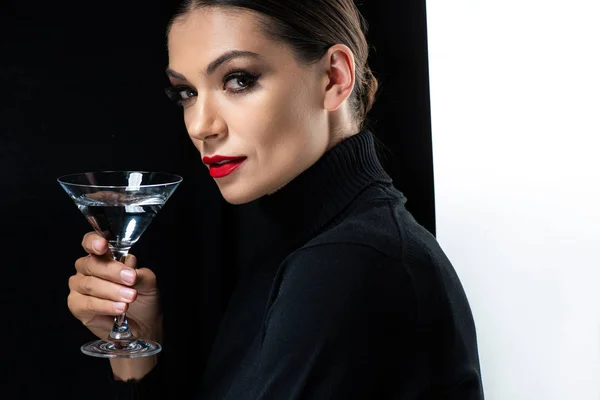 Schöne elegante Frau mit roten Lippen hält Martini isoliert auf weiß und schwarz — Stockfoto