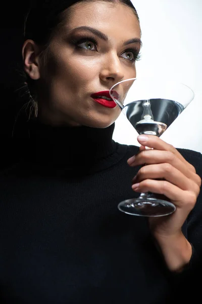 Portrait de belle femme élégante aux lèvres rouges buvant du martini isolé sur blanc et noir — Photo de stock