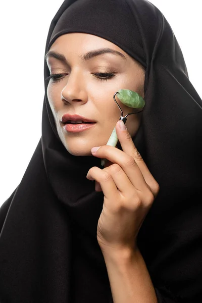 Jovem muçulmana no hijab usando rolo de jade isolado no branco — Fotografia de Stock