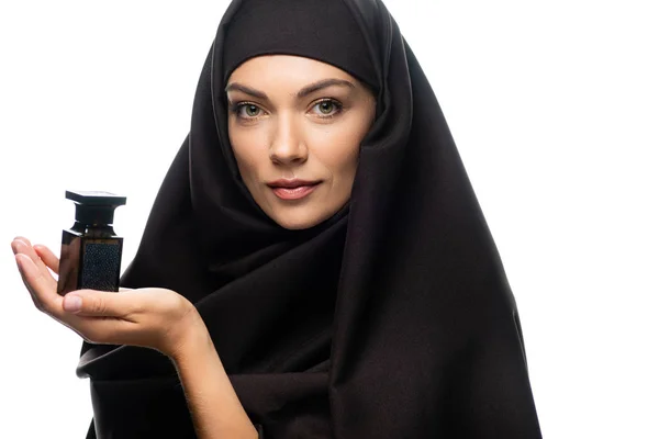 Junge muslimische Frau im Hijab hält Flasche Parfüm isoliert auf weiß — Stockfoto