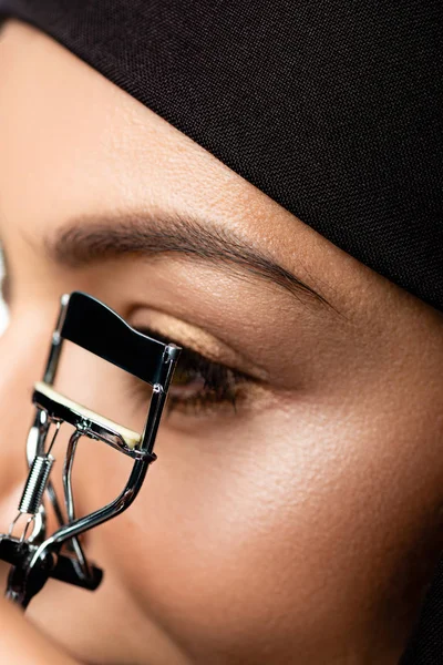 Vista de perto da jovem muçulmana no hijab usando cílios curler — Fotografia de Stock
