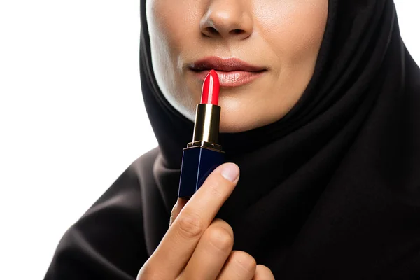 Abgeschnittene Ansicht einer jungen muslimischen Frau im Hijab, die roten Lippenstift isoliert auf Weiß aufträgt — Stockfoto