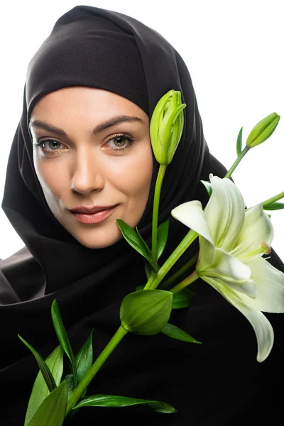 Young Muslim woman in hijab holding lily isolated on white — Stock Photo