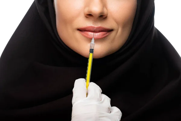 Partial view of young Muslim woman in hijab having beauty injection isolated on white, lip augmentation concept — Stock Photo