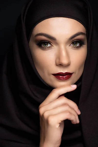 Молода мусульманка в Хіджабі з димними очима і червоними губами, ізольованими на чорному — стокове фото