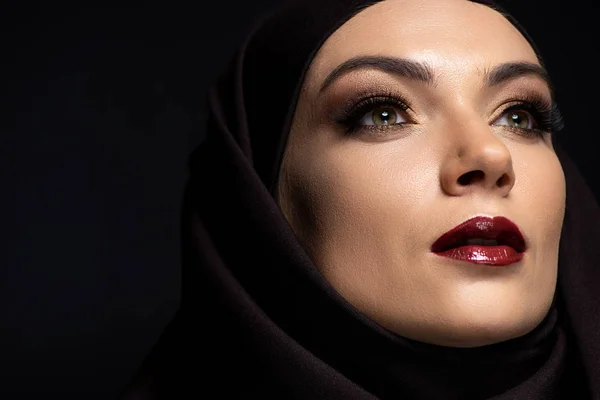 Молодая мусульманка в хиджабе с дымчатыми глазами и красными губами, изолированными на черном — стоковое фото
