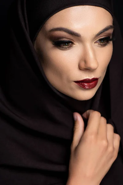 Beautiful Muslim woman in hijab with smoky eyes and red lips isolated on black — Stock Photo