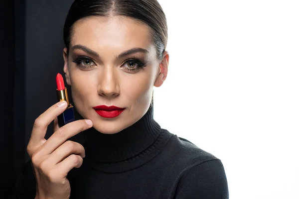 Belle femme avec des lèvres rouges tenant rouge à lèvres isolé sur blanc et noir — Photo de stock