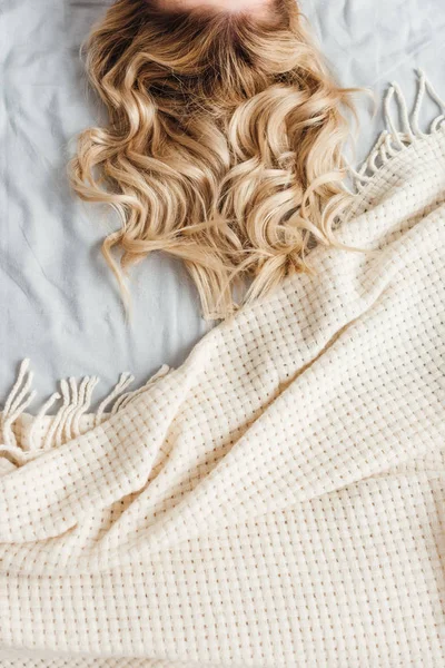 Обрізаний вид блондинки лежить на ліжку — стокове фото