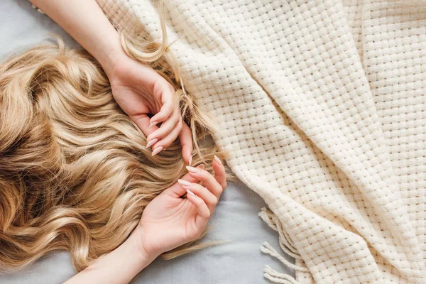 Ausgeschnittene Ansicht einer jungen blonden Frau, die auf dem Bett liegt — Stockfoto