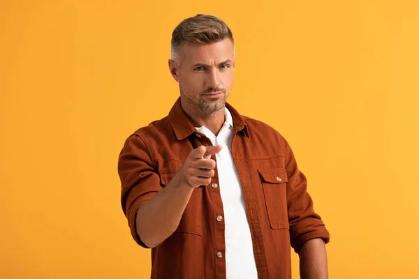 Selective focus of handsome man pointing with finger isolated on orange — Stock Photo