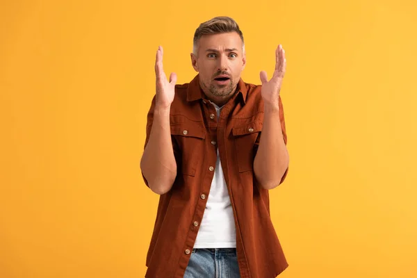 Homme choqué gestuelle en regardant la caméra isolée sur orange — Photo de stock