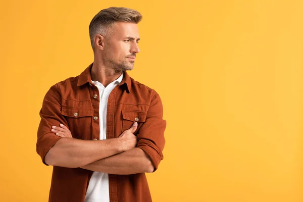 Bel homme debout avec les bras croisés isolés sur orange — Photo de stock