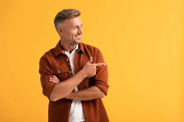 Hombre feliz señalando con el dedo aislado en naranja - foto de stock