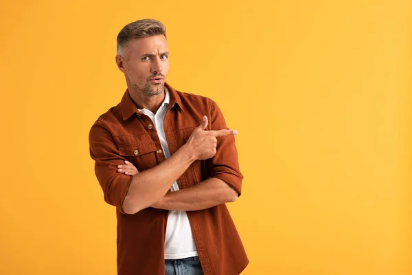 Überraschter Mann zeigt mit Finger isoliert auf Orange — Stockfoto