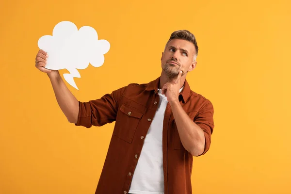 Pensive man holding black thought bubble isolated on orange — Stock Photo