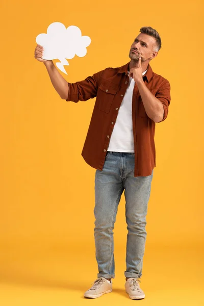 Hombre pensativo sosteniendo la burbuja del pensamiento en naranja - foto de stock